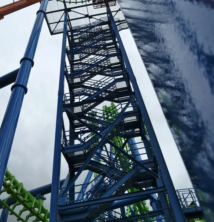 A blue painted steel tower with stairs against the sky